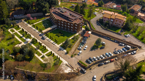 Aerial view of a residential building with private garden and parking for cars.