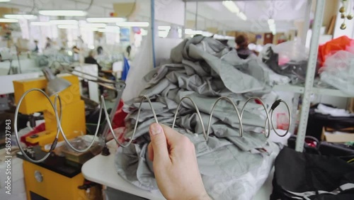 Woman hand holds metal spring in parachute sewing workshop