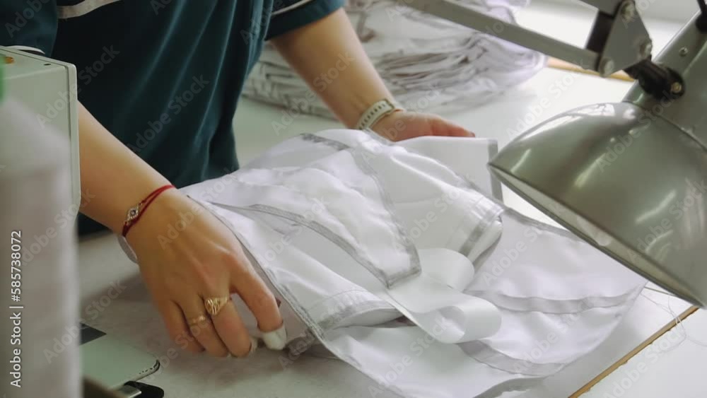 Worker folds and adjusts parachute detail in sewing workshop Worker folds and adjusts parachute detail in sewing workshop