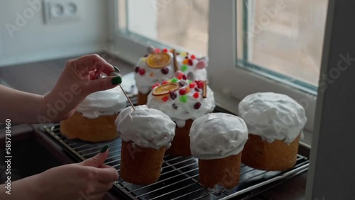 A Caucasian Woman's Hand decoretes freshly cooked Easter Cakes. Cooking homemade traditional Easter Cakes photo