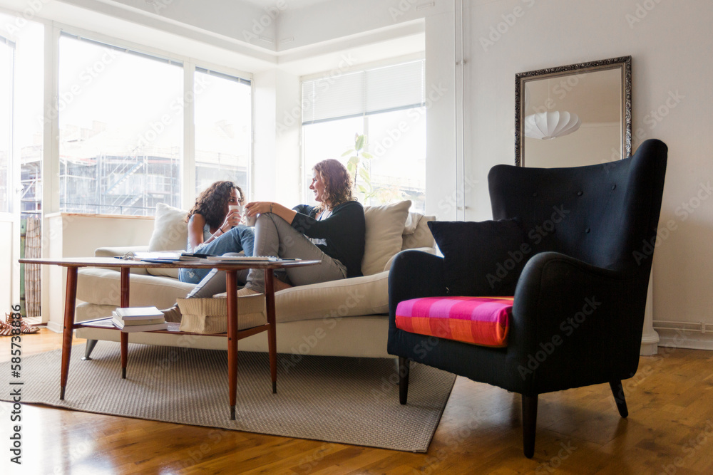 Two women sitting on sofa and talking Two women sitting on sofa and talking