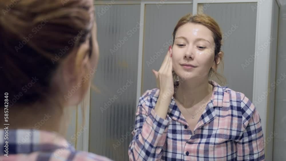 The 4k video of a woman using a natural stone massage tool to massage her under-eye area while applying an eye mask during her skincare routine. The 4k video of a woman using a natural stone massage tool to massage her under-eye area while applying an eye mask during her skincare routine.