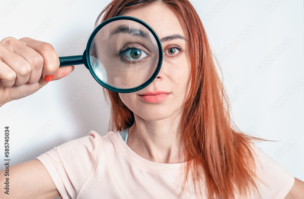 Cute woman holds a magnifying glass near her eye. Research, eye diseases, treatment. Cute woman holds a magnifying glass near her eye. Research, eye diseases, treatment.