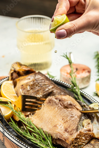 baked fish with lemon herbs and spices. two glasses of white wine, dinner concept. Restaurant menu, dieting, cookbook recipe top view
