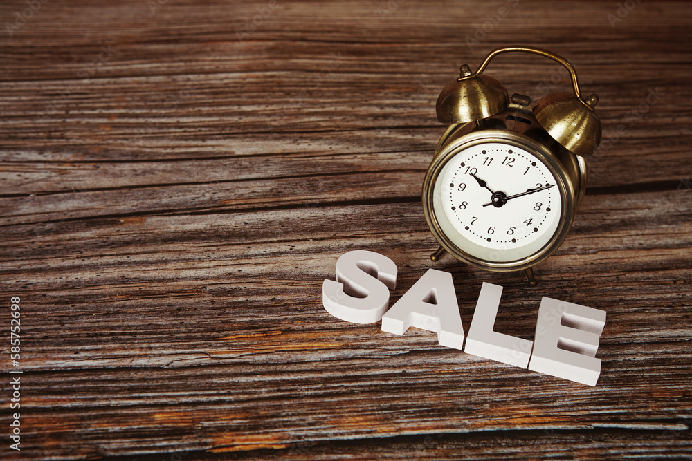Sale alphabet letters with alarm clock on wooden background Sale alphabet letters with alarm clock on wooden background