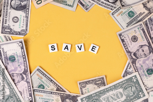 cash scattered on colorful background with the word save in the center