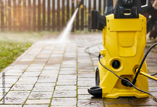 Pressure Cleaning with High Pressure Washer Karcher in Garden Park or Street. Cleaning Pavement Service concept. photo