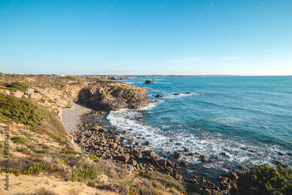 Breathtaking cliffs with pebble beach in the afternoon sun on the Atlantic coast at Vila Nova de Milfontes, Odemira, Portugal. In the footsteps of Rota Vicentina. Fisherman trail