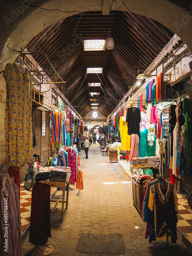 Busy Souk market street in the heart of the Medina of Marrakech, Morocco, selling colorful clothes