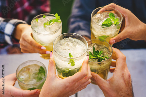 Close-up of Hands Toasting with Mojitos