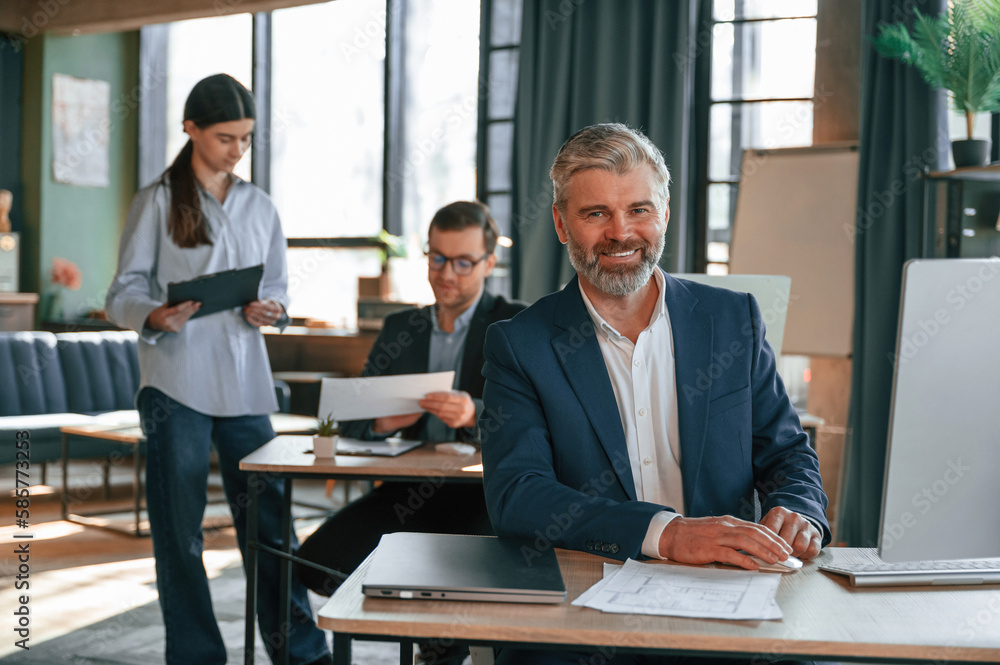 Man is smiling. Group of business people are working in the modern office Man is smiling. Group of business people are working in the modern office