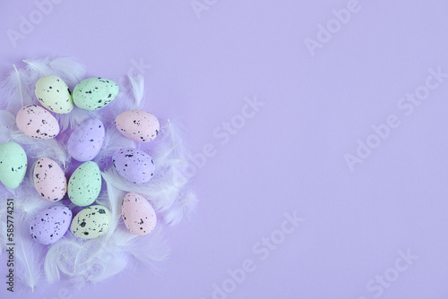 Colored Easter eggs on a purple background. Top View. Space for text, banner