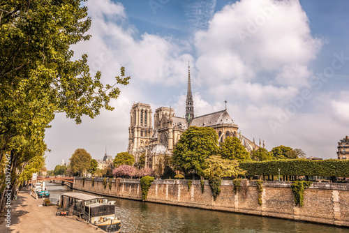 Notre Dame cathedral with houseboats on Seine during spring time in Paris, France