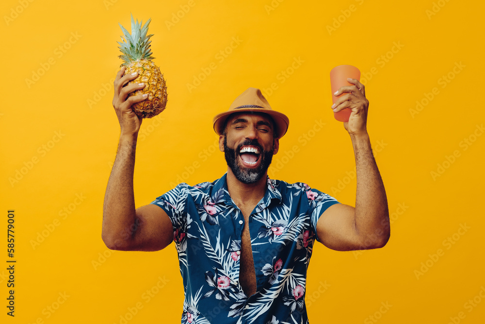 cheerful man wearing Hawaiian shirt and hat. Holding pineapple and pink cup - obrazy, fototapety, plakaty 