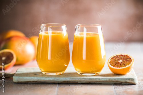Two mango lassi or kesar milk in glasses. Indian healthy ayurvedic cold drink with mango. Freshness lassi made of yogurt, water, spices, fruits and ice.