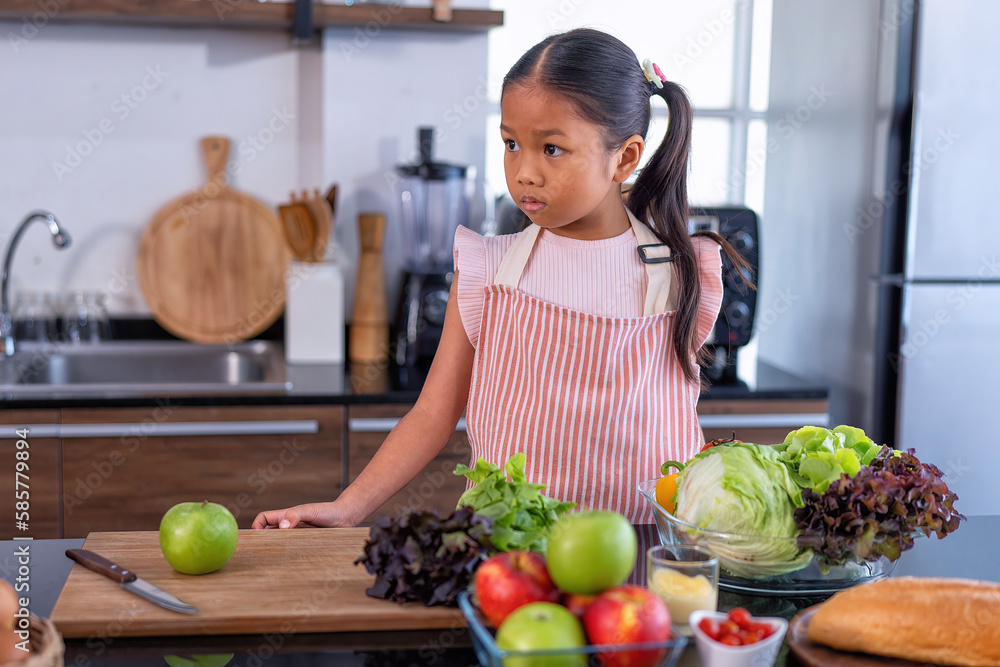 Fototapeta premium Daughter in the kitchen wait mon to learn online cooking clean food from the laptop computer