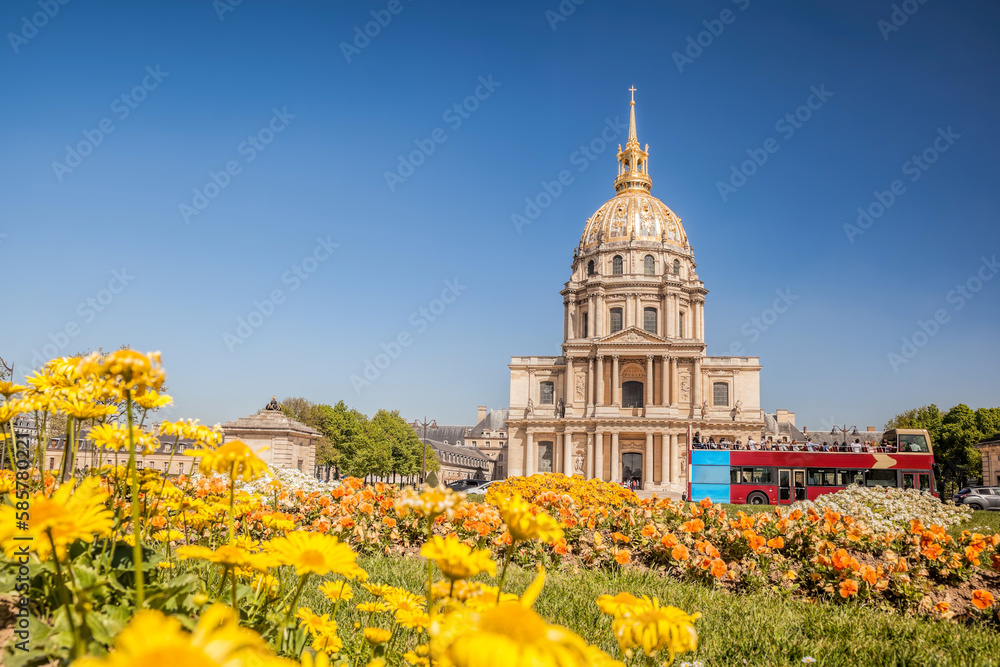 View of Les Invalides with spring flowers and tour bus in Paris, France