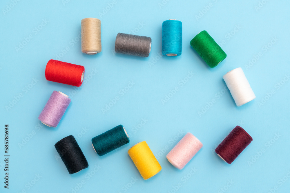 Randomly arranged colored spools of sewing threads with space in the center close-up Randomly arranged colored spools of sewing threads with space in the center close-up