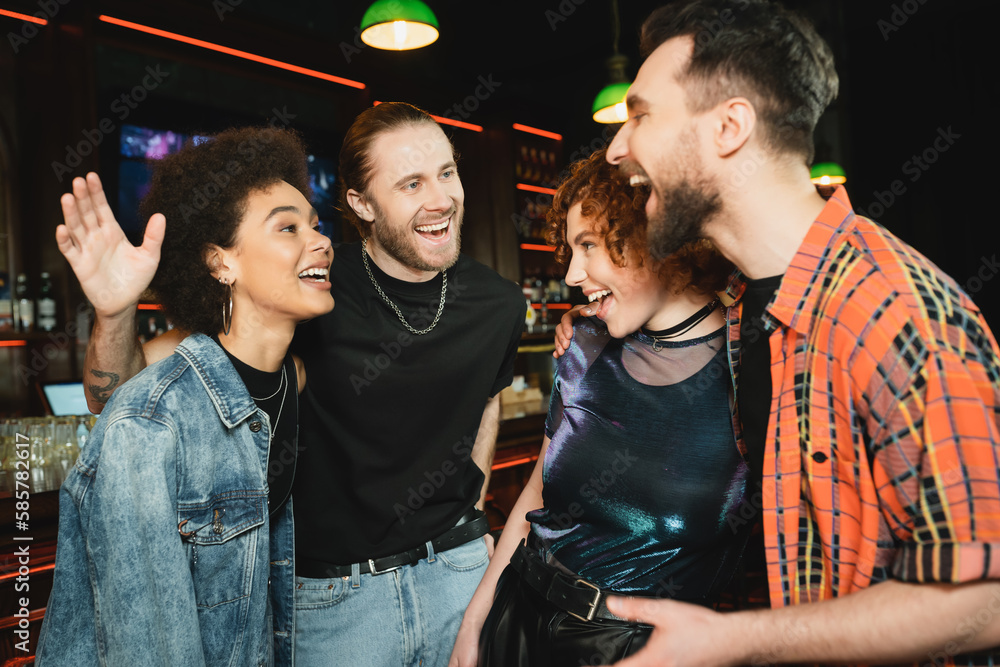 Cheerful multiethnic friends talking while spending time in bar. Cheerful multiethnic friends talking while spending time in bar.