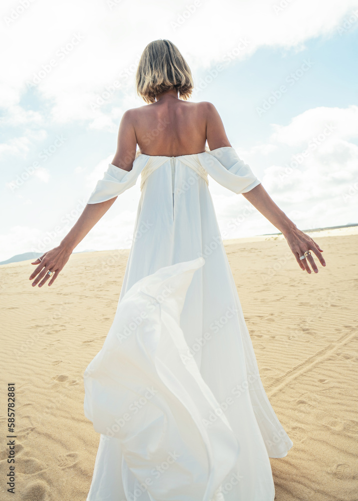 Photo of a woman in amazing white wedding dress posing on the desert, Photo of a woman in amazing white wedding dress posing on the desert,