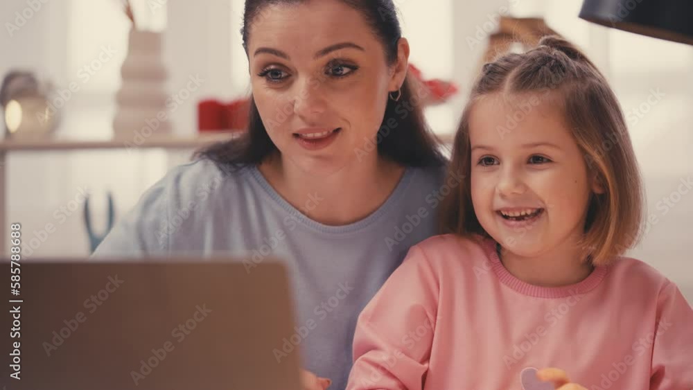 Mother and little daughter talking with tutor on laptop camera, online education Mother and little daughter talking with tutor on laptop camera, online education