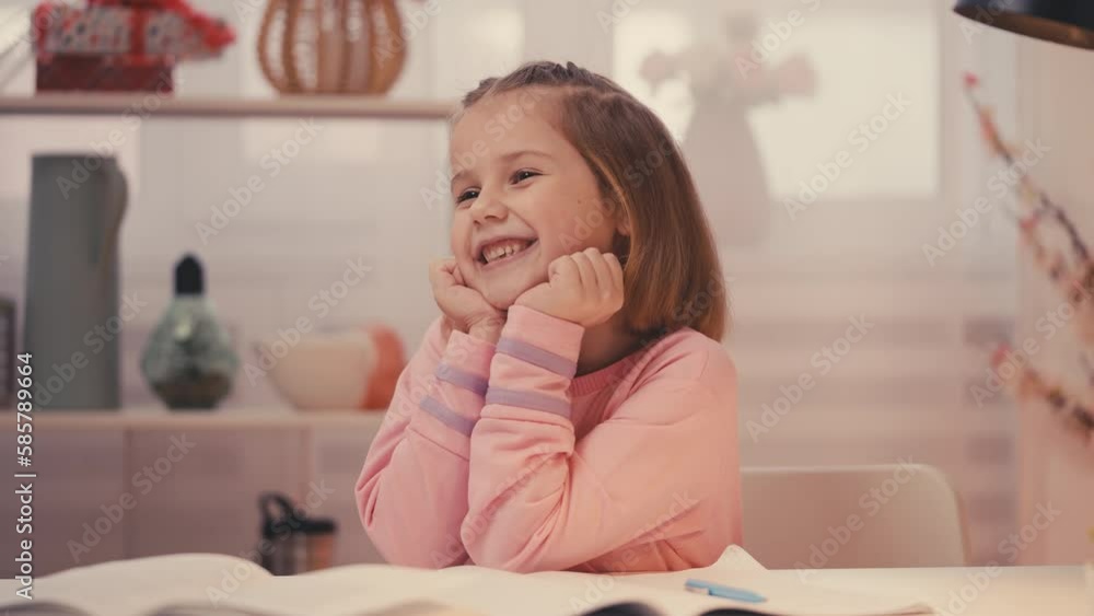 Diligent schoolgirl doing homework and smiling, continuing education form home Diligent schoolgirl doing homework and smiling, continuing education form home