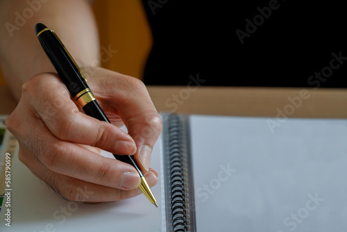 Businessman writing a message on a piece of paper,Man hand with pen writing on notebook
