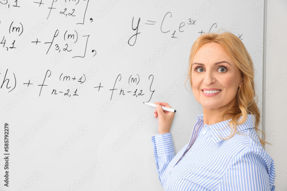 Fototapeta premium Professor writing down math equation on whiteboard