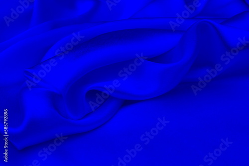 Satin beautiful blue silk fabric lies with drapery.