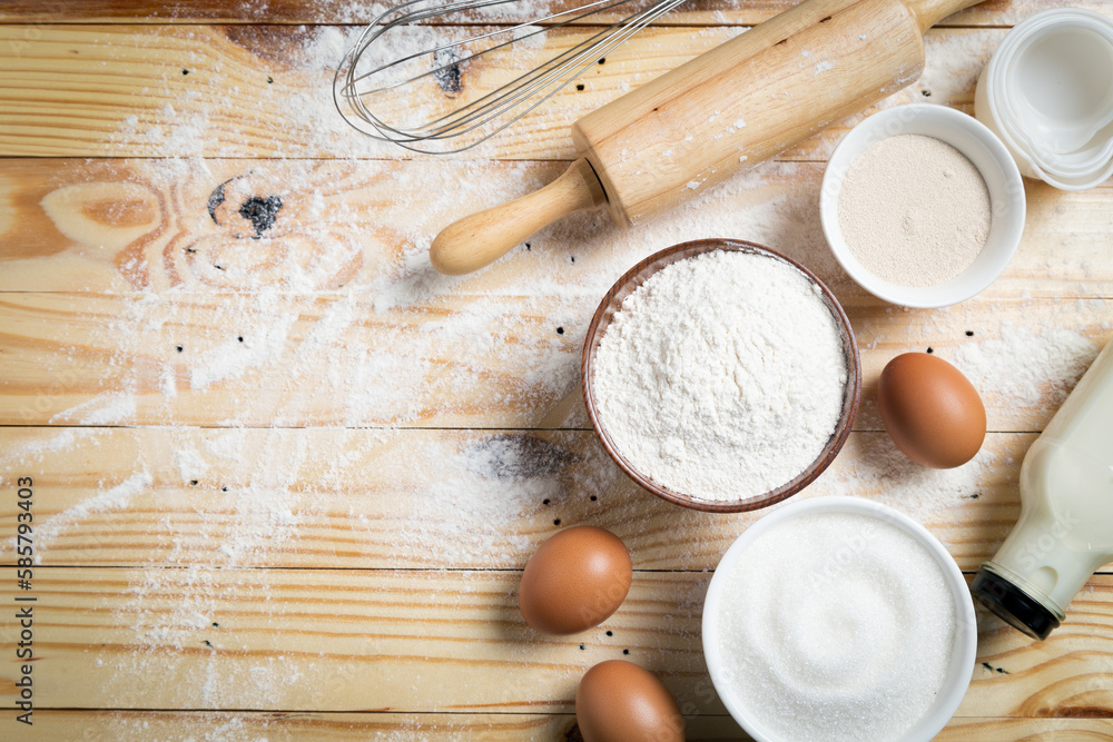 Homemade dough recipe (eggs, flour, milk, sugar) and kneaded dough on a wooden table. view from above Homemade dough recipe (eggs, flour, milk, sugar) and kneaded dough on a wooden table. view from above