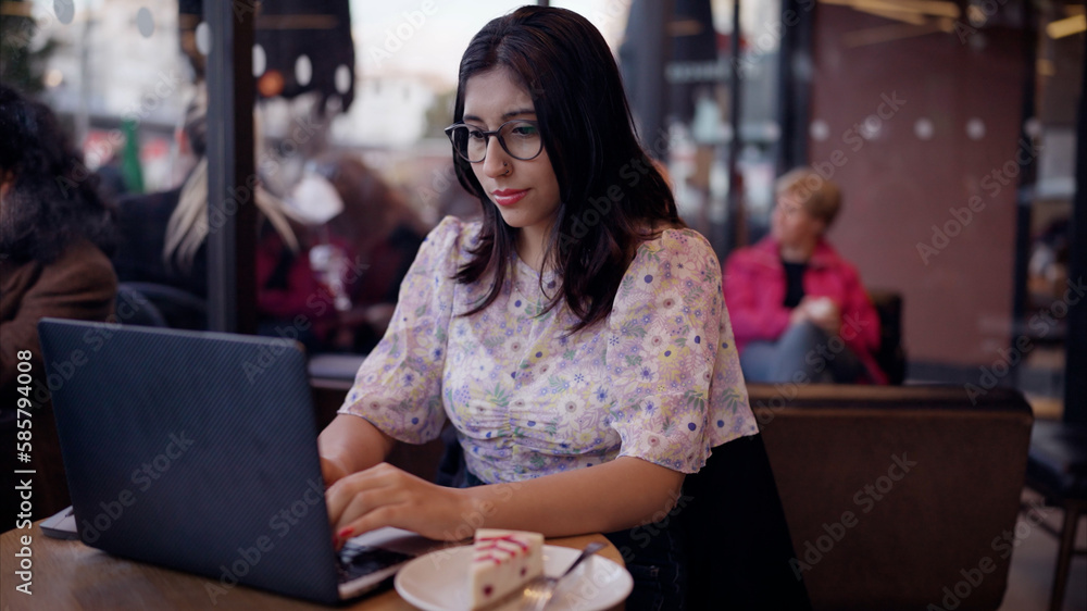 Woman working on laptop in cafe. Close-up portrait of nice-looking multi-race brunette beautiful elegant young woman looking into computer. Daily people life, fashion, beauty. Female portraits. 4k UHD