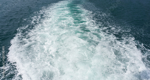 White splash foams behind a ship engine on the sea. Foam bubbles on sea water surface. 