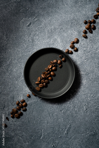 średnio palone ziarna kawy arabica, kawa ziarnista na talerzyku na betonowym kamiennym tle medium roasted arabica coffee beans, coffee beans on a plate on a concrete stone background