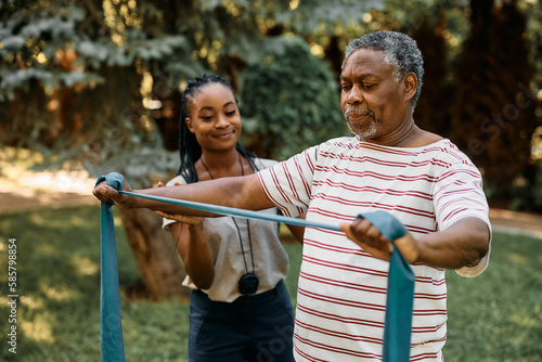Εκτύπωση καμβά Black senior practicing with power band on exercise class outdoors at residential care home