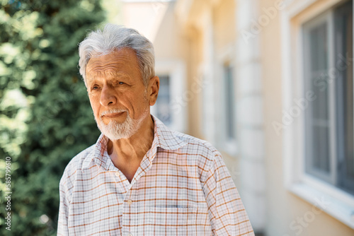 Portrait of thoughtful senior man outdoors in residential care home.