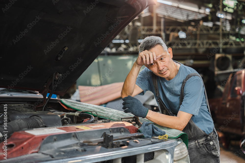 Concentrated technician and experienced car engine repair specialist, Confident Asian man auto mechanic working in automobile repair garage, industrial business of maintenance workshop service
