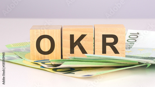 okr - text on wood cubes with euro bills