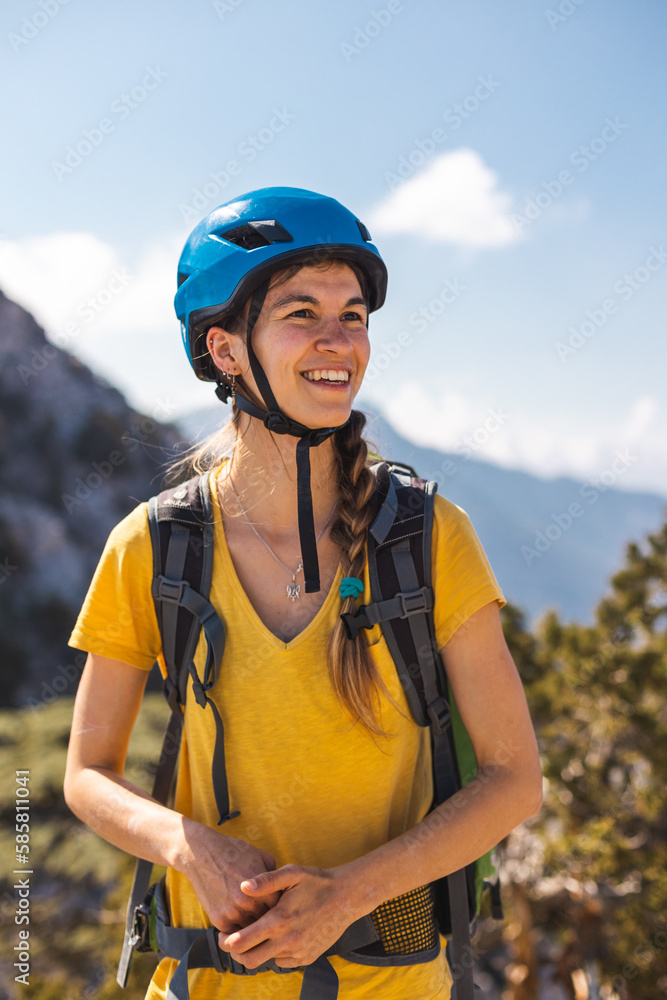 Portrait of a woman in a helmet for mountaineering and rock climbing against the backdrop of mountains. Safety in extreme sports. outdoor sports Portrait of a woman in a helmet for mountaineering and rock climbing against the backdrop of mountains. Safety in extreme sports. outdoor sports