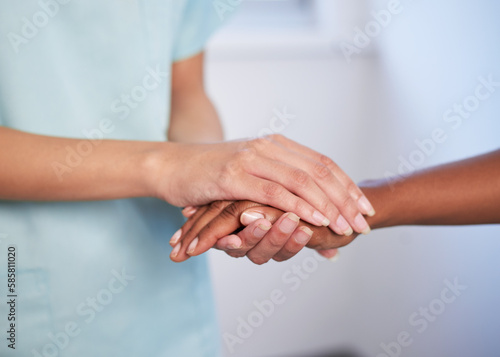 Close up of nurse holding patient's hand during difficult diagnosis, counselling