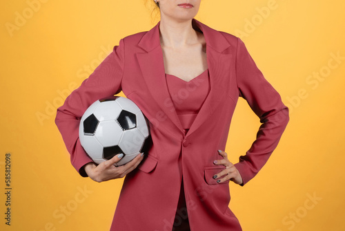 Fototapeta Naklejka Na Ścianę i Meble -  Beautiful young woman businesswoman with soccer ball posing on yellow background