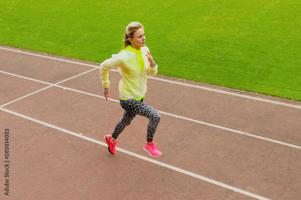 Outdoor training. A young woman runs around the stadium. Healthy lifestyle