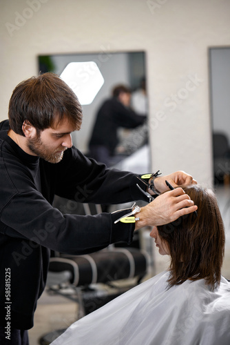 male hairdresser working with client at hair salon