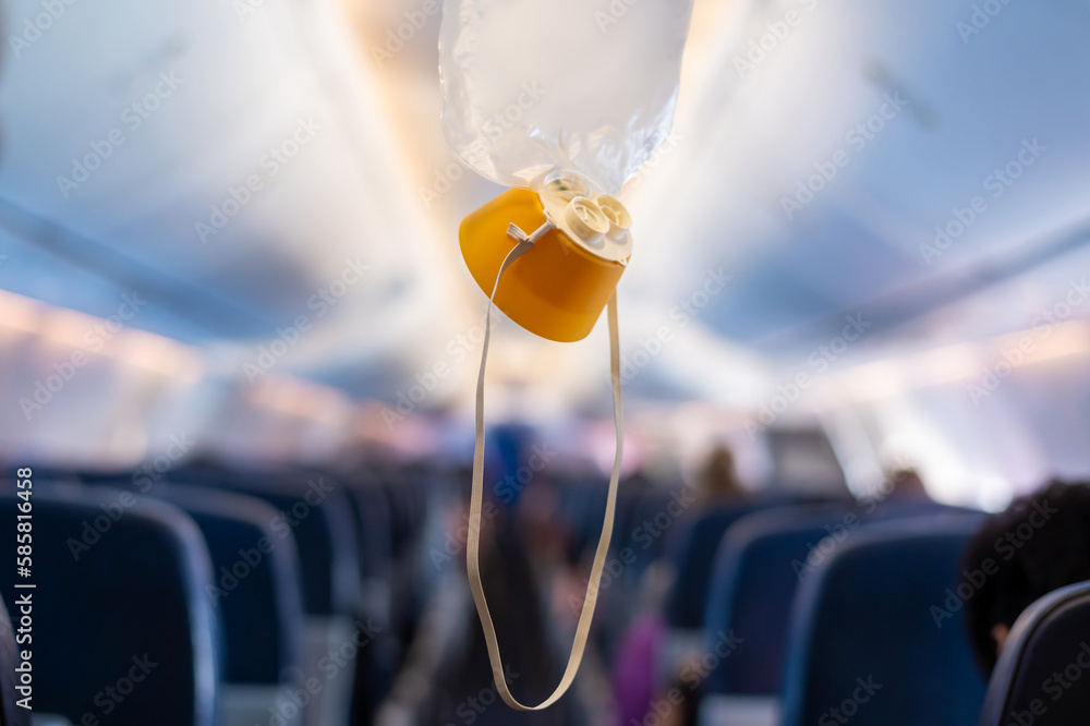 oxygen mask drop from the ceiling compartment on airplane.. - obrazy, fototapety, plakaty 