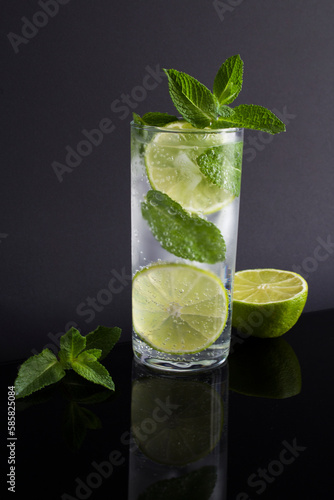 Mojito cocktail in the drinking glass on the black background. Close-up.