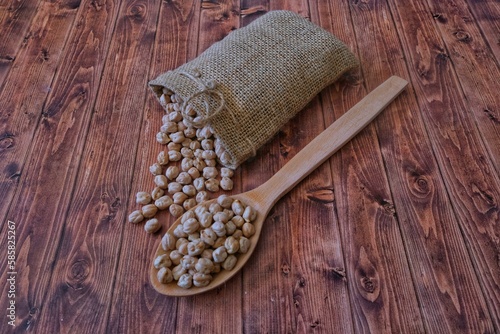 Chickpeas in a wooden spoon. Chickpeas in a cloth bag.