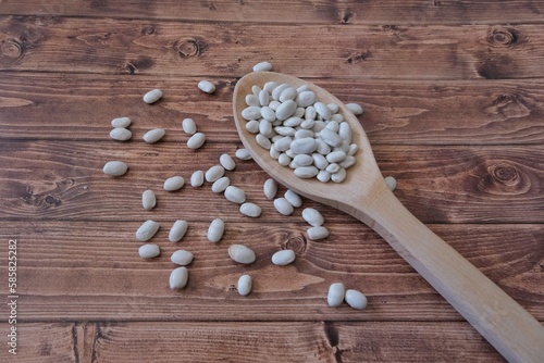 Beans in a wooden spoon. Beans in a cloth bag.