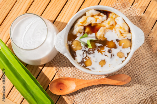 Bubur Sumsum or Candil porridge, Indonesian rice flour porridge with sweet potato sticky rice balls, served with palm sugar sauce in a white bowl photo