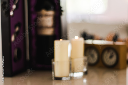 Lit cndles in glass containers out of focus