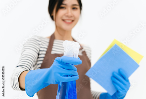 Happy asian woman in blue gloves smiling while posing with sponge and spray bottle. portrait looking at camera . isolated on white background.