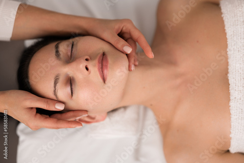 Crop masseuse massaging clients face